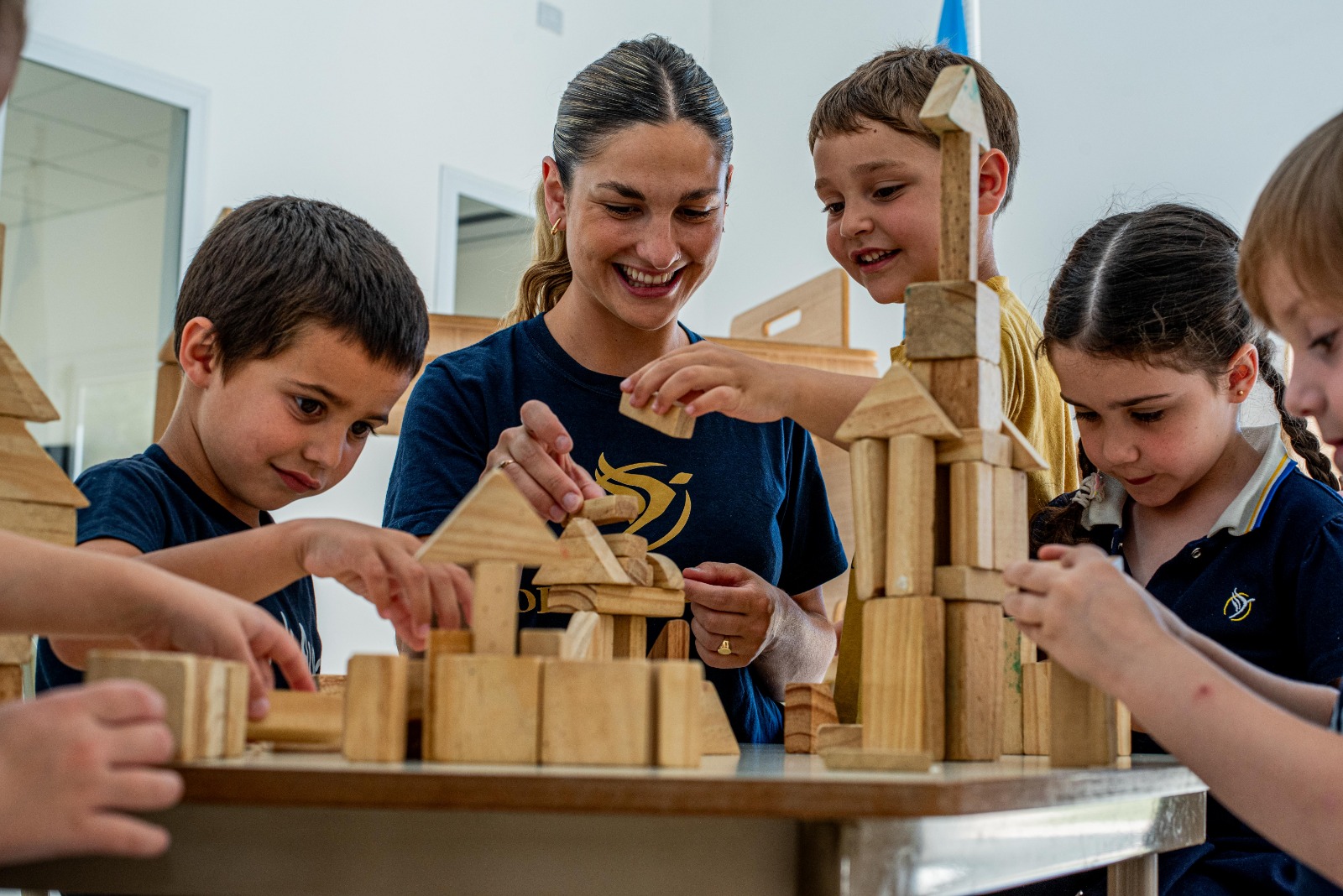 Docente trabajando con alumnos en una actividad de construcción